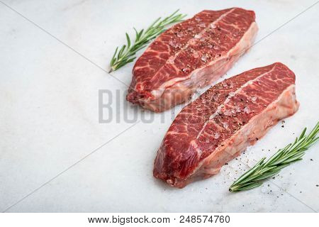 Raw Fresh Meat Top Blade Steaks On Light Background. With Copy Space.