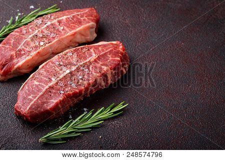 Raw Fresh Meat Top Blade Steaks On Dark Background. Top View With Copy Space.
