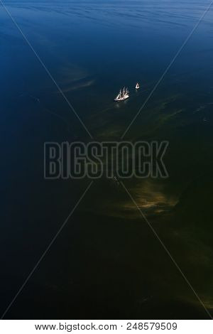 Two Lonely Sailboats In The Middle Of The Sea. Aerial View From Above.