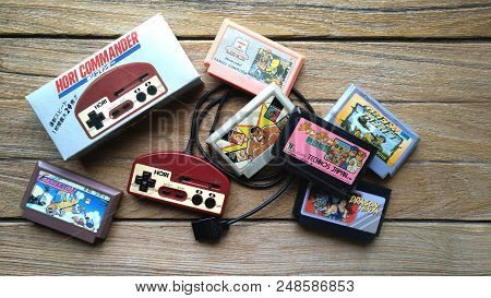 Bangkok, Thailand - March 31, 2017 : Old Hori Controller And Game Cartridges On Wooden Background. I