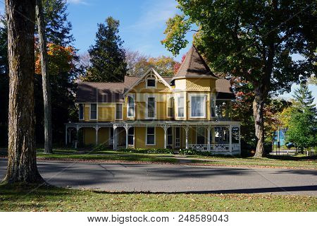 Bay View, Michigan / United States - October 17, 2017: A Large Yellow Victorian Cottage With A Wrapa