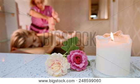 Massage Concept. Beautiful Young Woman Reciving Relaxing Massage At Luxury Spa Salon With Warm Cozy 