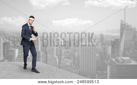 Young suited karate trainer doing karate tricks on the top of a metropolitan city