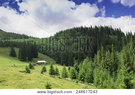 Photo Of Kolyba In Mountain Village In The Summer Under Beautiful Cloudy Sky. Ukraine, Carpathians, 