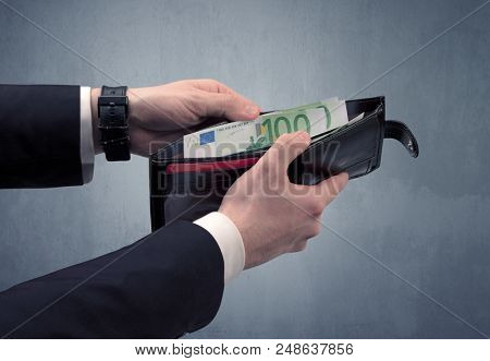 Businessman's hand in suit takes out eruo from his wallet