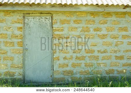 Outdoor Old Facade White Closed Door On Ecological Shells Brick Yellow Wall Background, Copy Space.