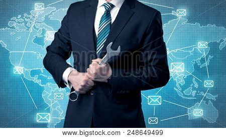 Businessman holding tool with global map graphic on the background