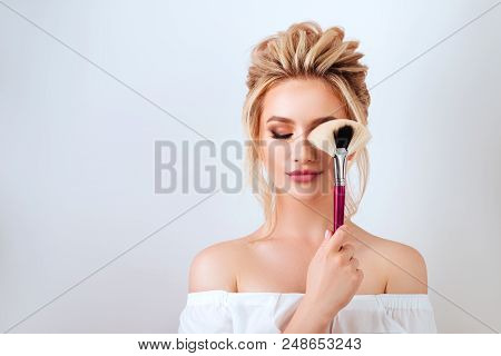 Fashion Glamour Portrait Of Happy Smiling Blonde Woman Long Wavy Hair Style Holding Brush Over Light