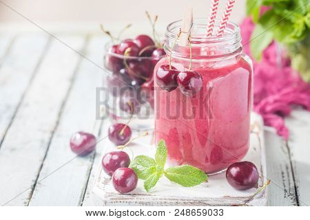 Healthy Cherry Smoothie With Frozen Strawberry, Coconat Water And Honey In Glass On White Wooden Tab