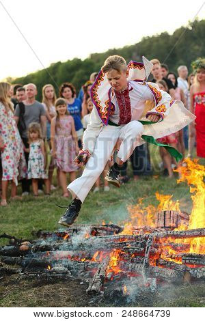 Kyiv, Ukraine - July 6, 2018: Young People Jump Over The Flames Of Bonfire During The Traditional Sl
