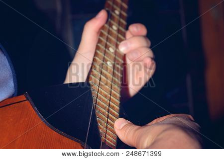The Boy Plays The Guitar And Takes Chords, Dombra On The Background Of The Piano.
