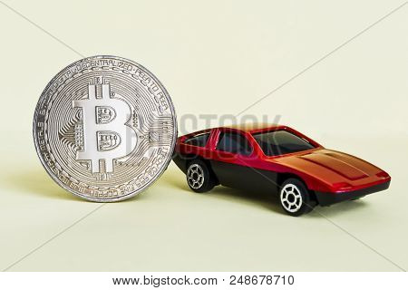 Close-up View Of Bitcoin And Red Car.