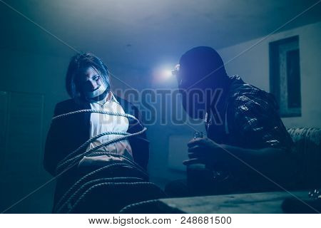 Businessman With Dark Hair Is Sitting On Chair. He Is Tied To It With Ropes. Guy's Mouth Is Closed W