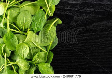 Fresh Baby Spinach Leaves Top View On Black Wood Background Left Corner