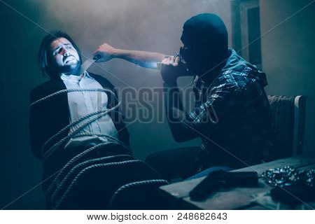 A Picture Of Bad Killer Recording Video. He Is Holding Knife Close To Victim's Thoat And Looking At 