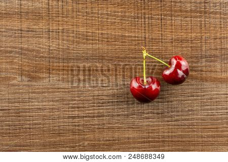 Group Of Two Whole Sweet Bright Red Cherry Flatlay On Brown Wood