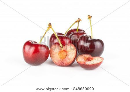 Group Of Four Whole Two Halves Of Sweet Bright Red Cherry Isolated On White