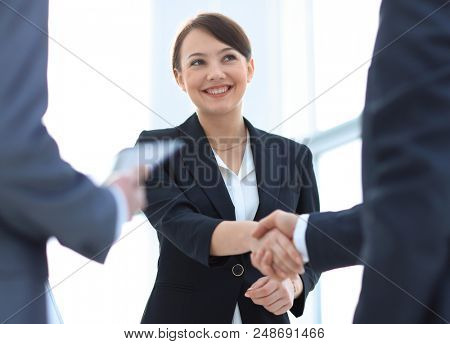Businesswoman shaking hands with a businssman during a meeting