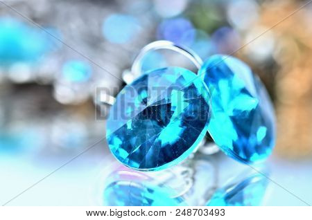 Close-up Of Blue Earrings Jewels - Reflection Effect - Colored Backgrounds