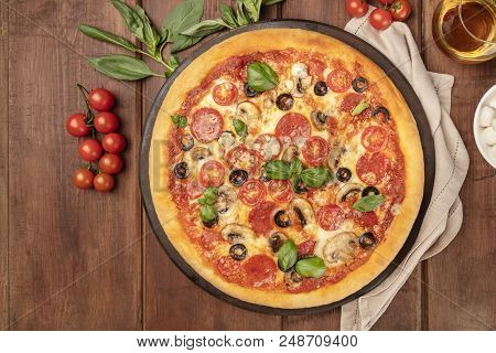 Overhead Photo Of Pepperoni Pizza With Glass Of White Wine, Cherry Tomatoes And Fresh Basil Leaves, 