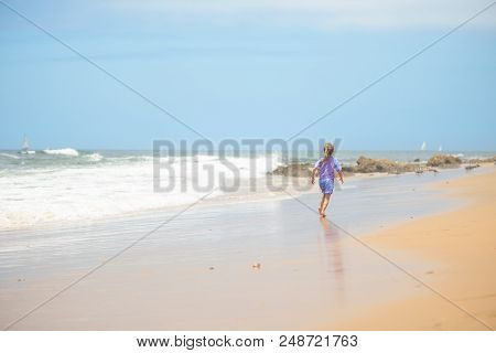 Happy Girl In Purple Swimsuit Running On The Beach In The Waves, Family On Vacation, View From Behin