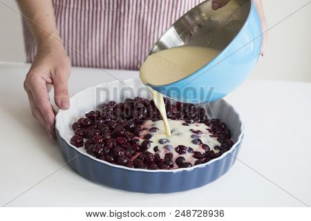 Clafoutis Cherry Pie. Young Woman Cooking In Kitchen. Preparation Of A French Pie With Cherries