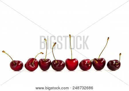 Black Cherries Fruit Lined Up Horizontally On A White Background