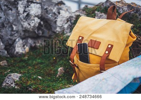 Hipster Hiker Tourist Yellow Backpack And Mobile Phone, Map On Background Green Grass Nature In Moun