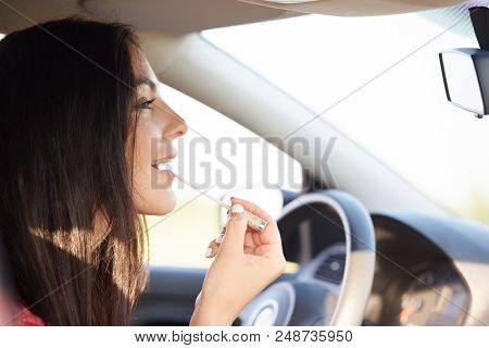 Gorgeous Elegant Young Female Uses Mirror In Car To Appy Lipstick On Lips, Cares Of Her Beauty, Has 