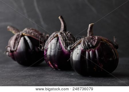 Fresh Italian Type Eggplants Or Aubergines With Water Drops Closeup On Black Background