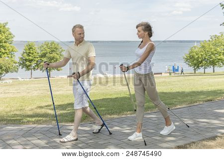 Young Couple Hiking In The Nature Nordic Walking