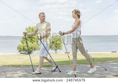 Young Couple Hiking In The Nature Nordic Walking