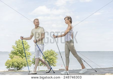 Young Couple Hiking In The Nature Nordic Walking