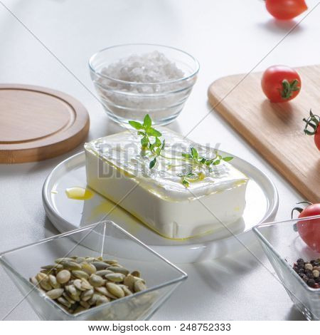 Peeled sunflower seeds, cheese, tomatoes and salt preseved on a white kitchen table. Ingredients for step-by-step cooking healthy salad.