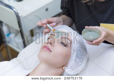 Young Beautiful Girl Receiving Pink Mask In Spa Beauty Salon - Indoors