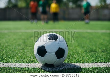 Selective Focus Of Football Ball And Players On Green Football Field