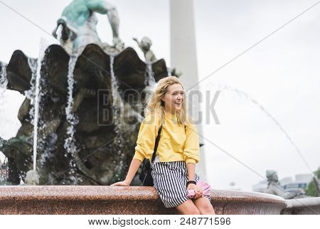 Happy Young Woman In Front Of Neptunbrunne, Berlin, Germany