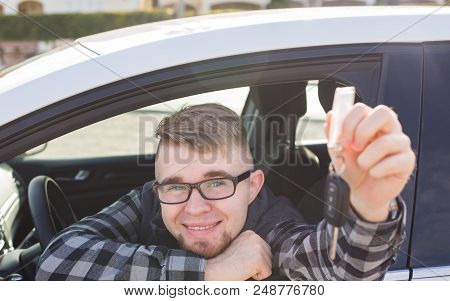 Young Man Sitting In Car Holding Car Keys.