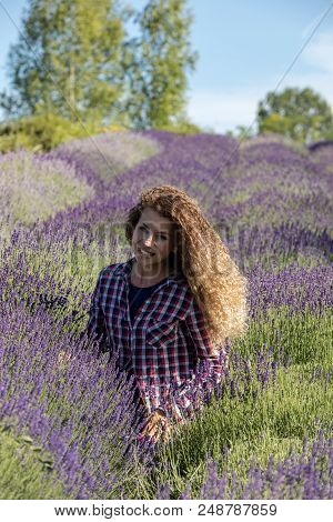 Ostrow, Poland - June 6, 2018: Beautiful  Woman With Long Curly Hair In The Middle Of A Lavender Fie