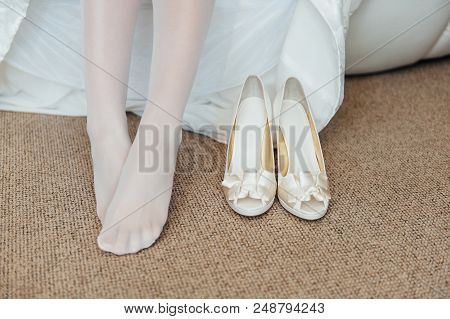 Beautiful Woman Legs In Whitel Shoes. Wedding Dress And Shoes. Morning Of The Bride.