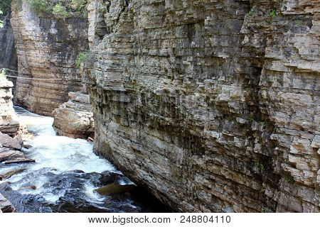 Large Rocks That Jut Out Over The Rushing Water Flowing Out Of The
Nearby Mountains.