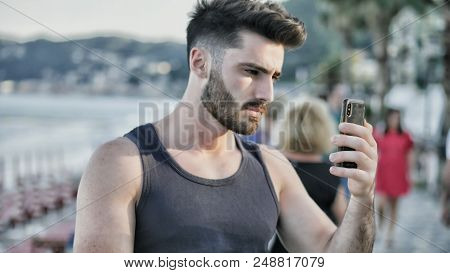 Young Man At Beach Taking Selfie Photo With His Cell Phone