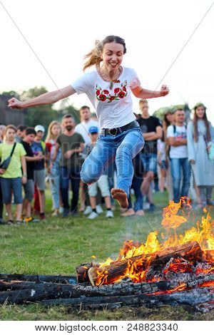 Kyiv, Ukraine - July 6, 2018: Young People Jump Over The Flames Of Bonfire During The Traditional Sl