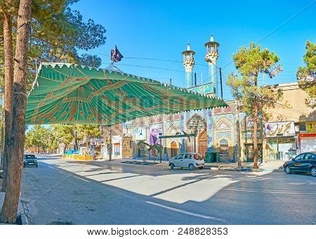 Kerman, Iran - October 15, 2017: The Shady Street With Coniderous Trees, Large Tent In Front Of Reli