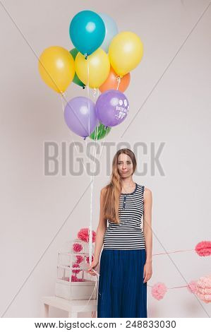 Blonde With Colored Balls On White Background. Studio Portrait Of An Attractive Girl Waiting For Her