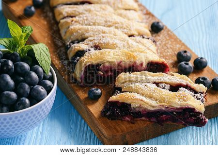 Homemade Blueberry Puff Pastry Braid, On Blue Wooden Background.