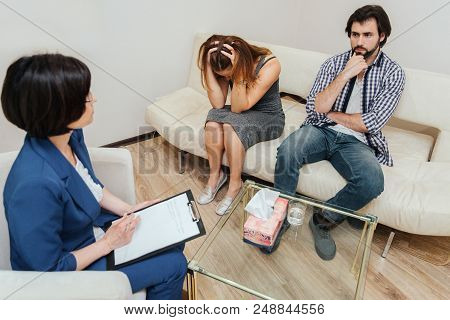 Desparate People Are Sitting In Room With Therapist And Working With Her. Girl Is Looking Down And H
