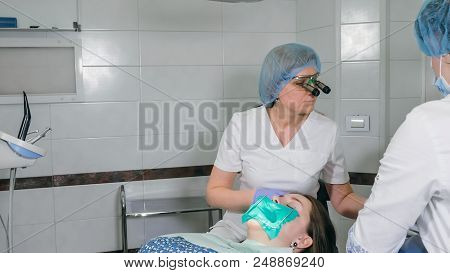 Woman At Dentist Clinic Gets Dental Treatment To Fill A Cavity In A Tooth. Dental Restoration And Co