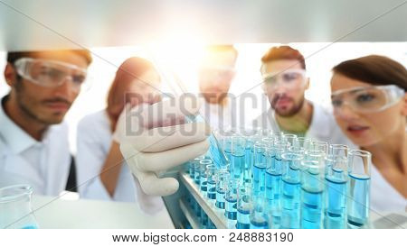 background image is a group of microbiologists studying the liqu