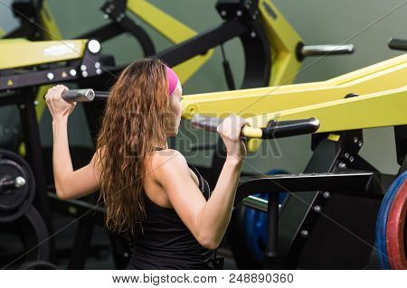 Sport, Fitness, Lifestyle And People Concept - Close Up Of Young Woman Flexing Muscles On Cable Gym 